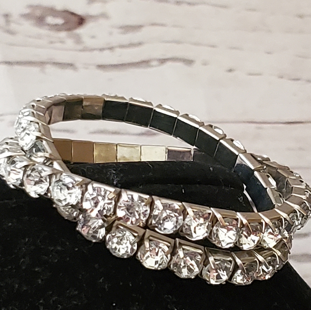 Two silvertone metal stretch bracelets with clear rhinestones